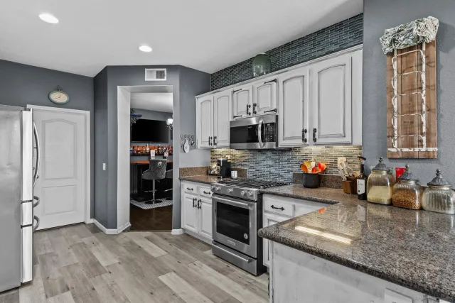 a kitchen with stainless steel appliances granite countertop a stove refrigerator and microwave