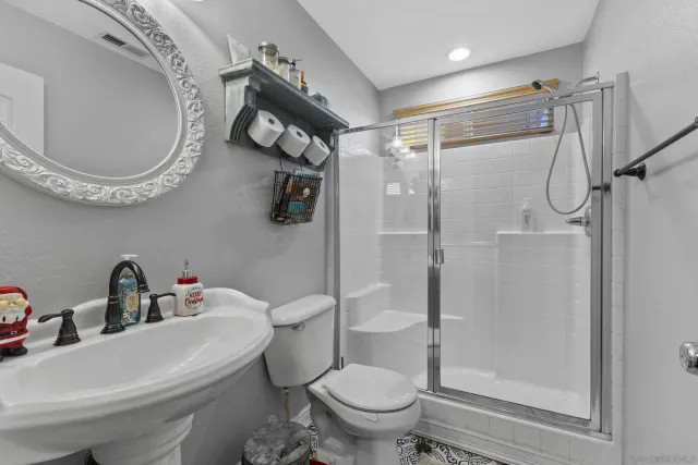 a bathroom with a toilet sink shower and mirror