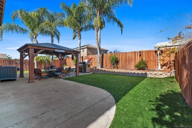 a view of a house with a yard and sitting area