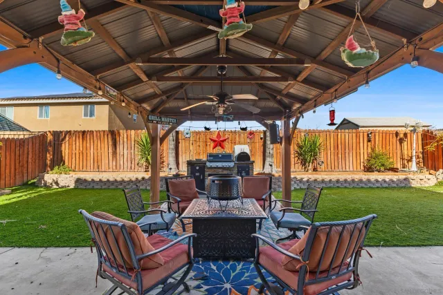 a view of a patio with a table chairs and a yard
