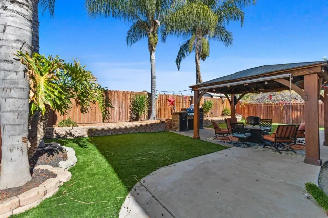 a view of a backyard with a garden and entertaining space