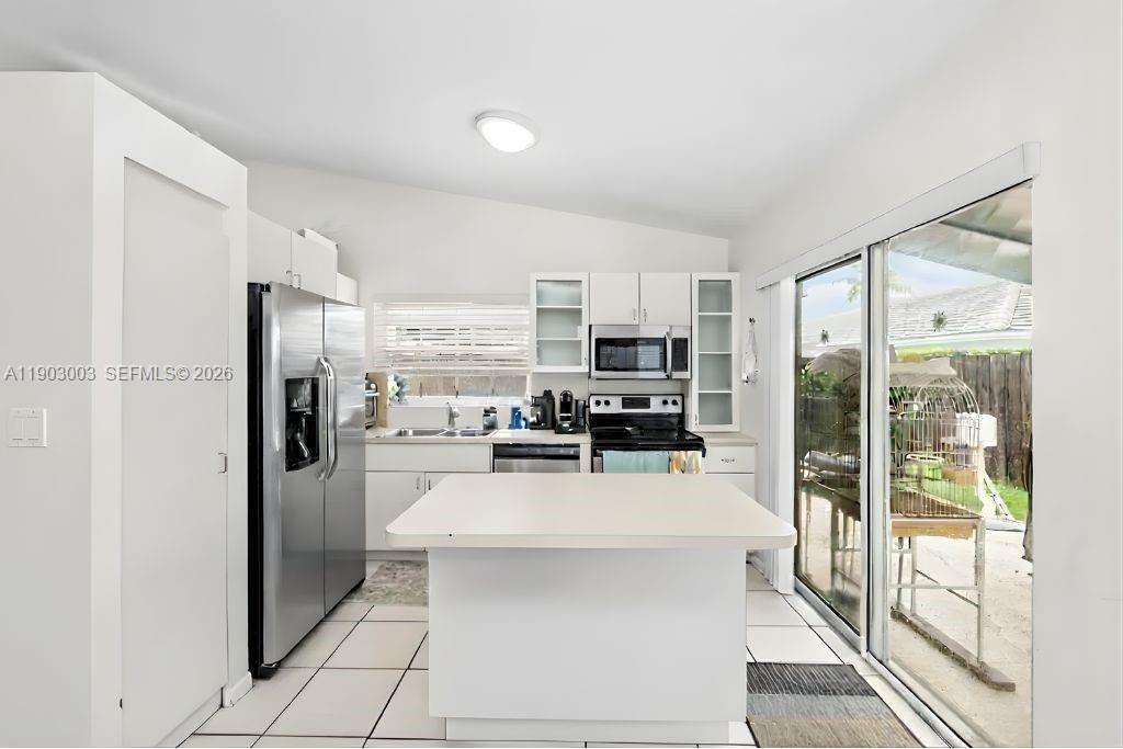 6410 Southwest 112th Place Miami, FL 33173 - Photo 8 of 19 a kitchen with a refrigerator a sink and a stove top oven