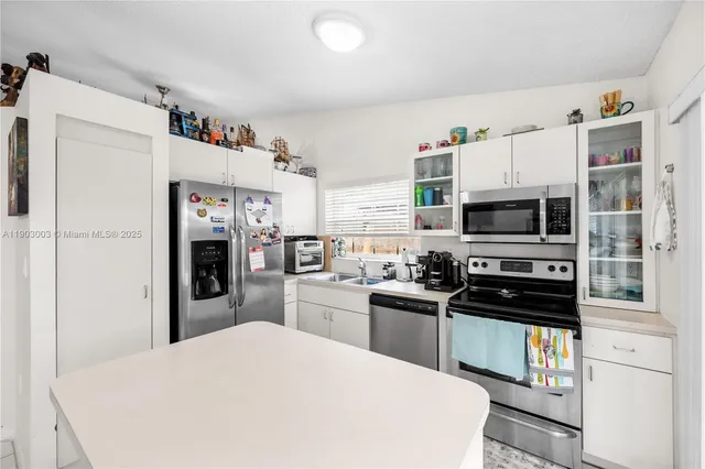 a kitchen with stainless steel appliances a refrigerator stove microwave and sink