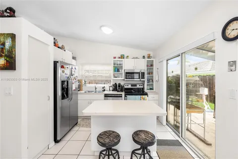 a kitchen with a refrigerator a stove top oven a sink and a window