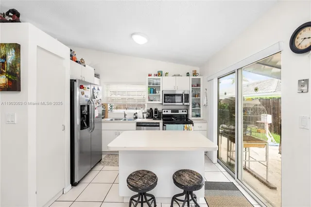 a kitchen with a refrigerator a stove top oven a sink and a window