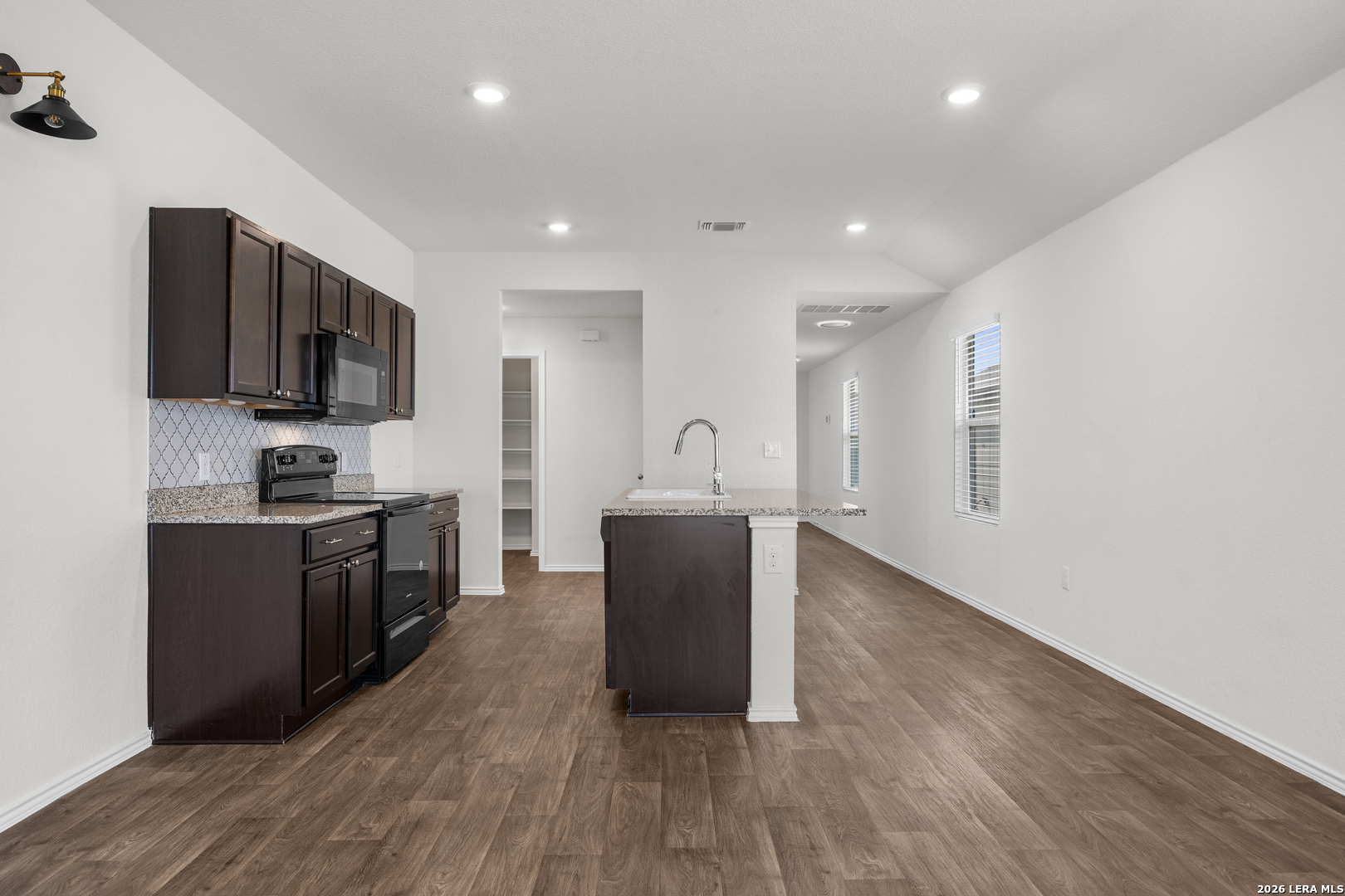14809 Bajada Road Manor, TX 78653 - Photo 13 of 30 a kitchen with a refrigerator and a stove top oven