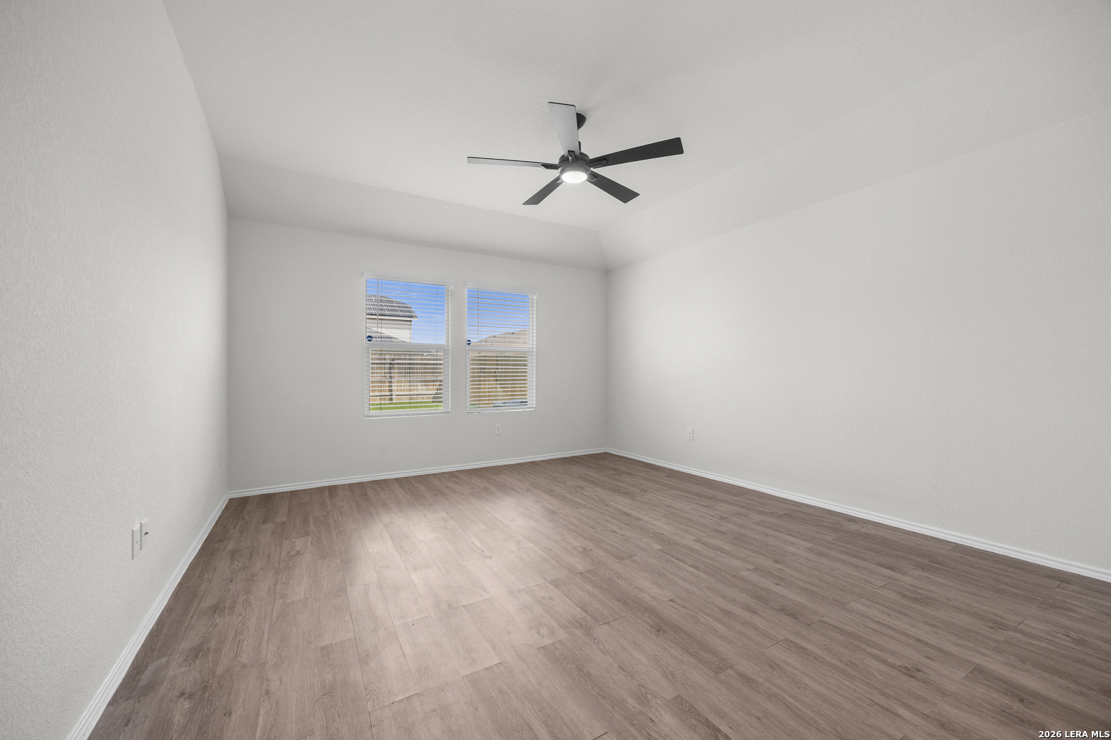 14809 Bajada Road Manor, TX 78653 - Photo 15 of 30 an empty room with wooden floor ceiling fan and windows