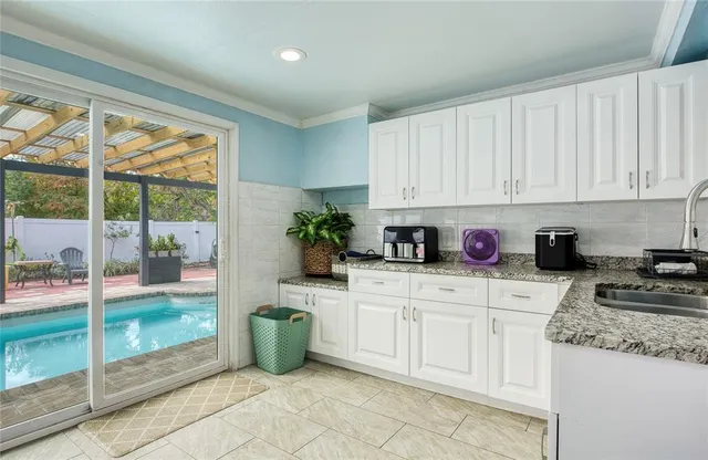a kitchen with stainless steel appliances granite countertop a stove a sink and white cabinets
