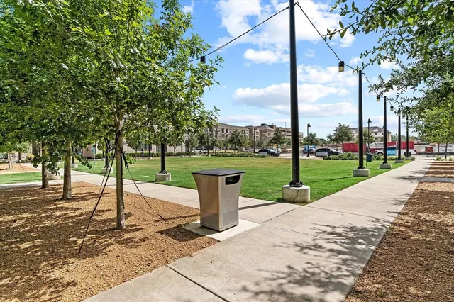 a view of a brick building next to a yard with big trees