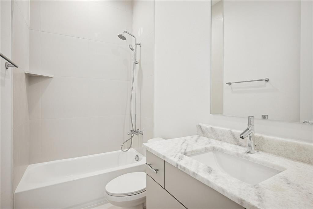 4066 Oak Circle Addison, TX 75001 - Photo 30 of 31 a bathroom with a granite countertop sink toilet and shower