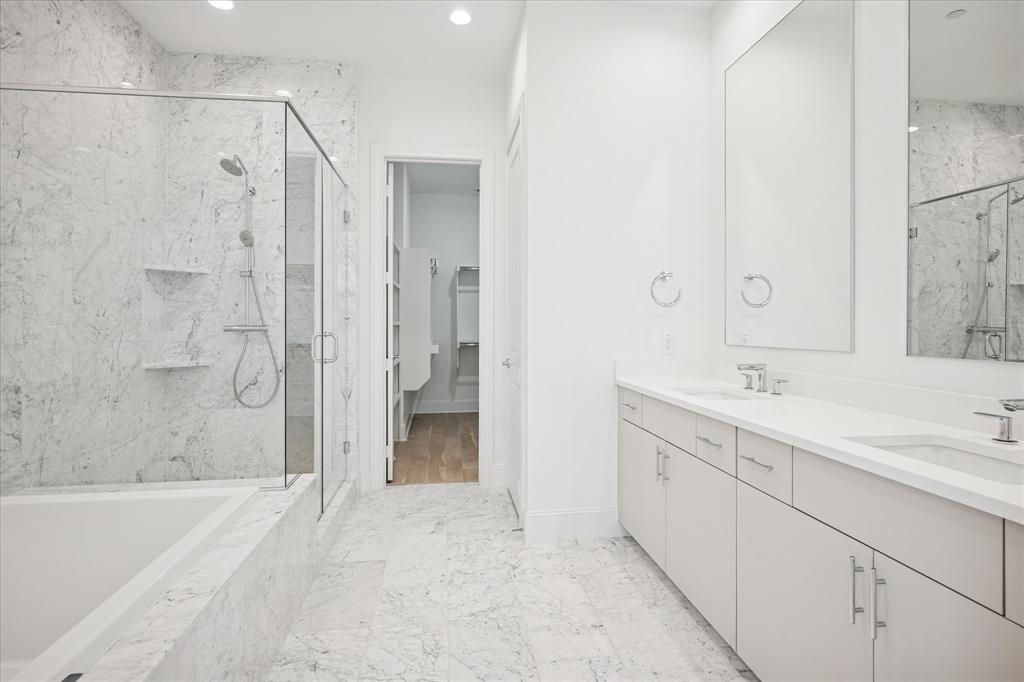 4066 Oak Circle Addison, TX 75001 - Photo 9 of 31 a bathroom with a bathtub shower sink vanity and a mirror
