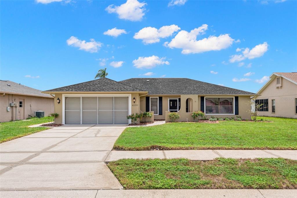 4530 Zack Drive New Port Richey, FL 34653 - Photo 1 of 1 a front view of a house with a garden and yard