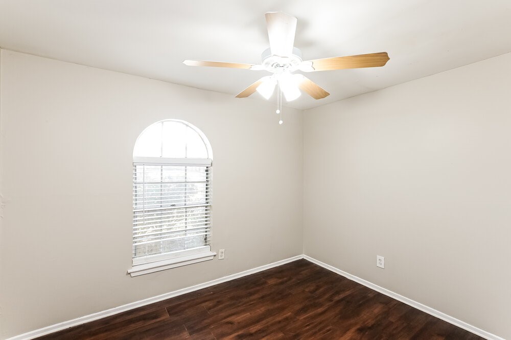 2703 Wood River Road Spring, TX 77373 - Photo 14 of 16 an empty room with wooden floor chandelier fan and window