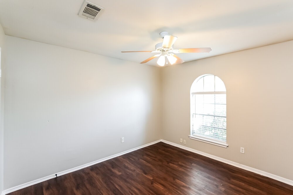2703 Wood River Road Spring, TX 77373 - Photo 15 of 16 an empty room with wooden floor fan and windows
