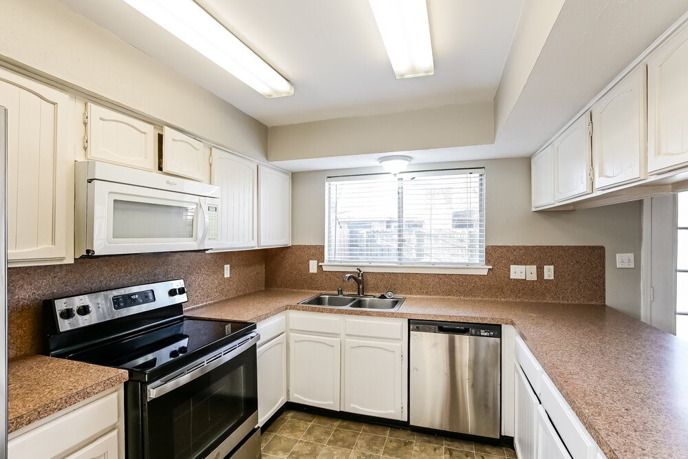 2703 Wood River Road Spring, TX 77373 - Photo 6 of 16 a kitchen with granite countertop a sink cabinets stainless steel appliances and a window