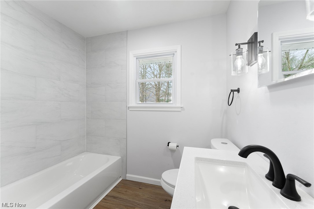 1707 Brookfield Road Hubbard, OH 44425 - Photo 14 of 30 Full bathroom featuring a healthy amount of sunlight, toilet, hardwood / wood-style flooring, and sink