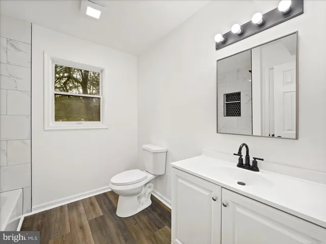 a bathroom with a sink mirror and toilet