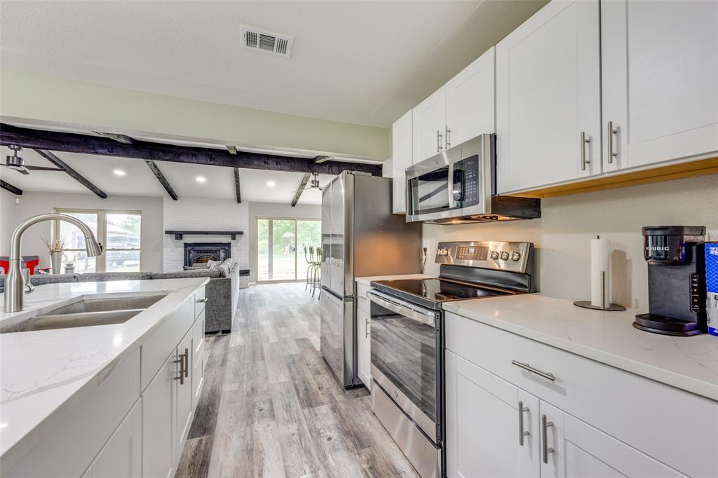 738 Campground Road Sherman, TX 75090 - Photo 18 of 40 a kitchen with granite countertop a sink a counter space stainless steel appliances and cabinets