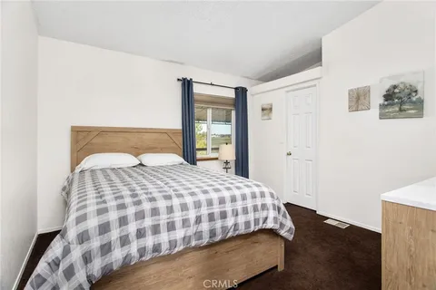 a bedroom with a large bed and wooden floor