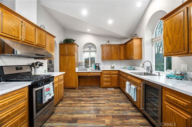 a large kitchen with stainless steel appliances granite countertop a stove a sink dishwasher and cabinets with wooden floor