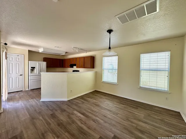 a view of a kitchen with a microwave and wooden floor