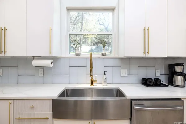 a kitchen with a sink a stove and cabinets