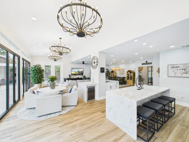 a very nice looking living room with a dining table a chandelier and couches