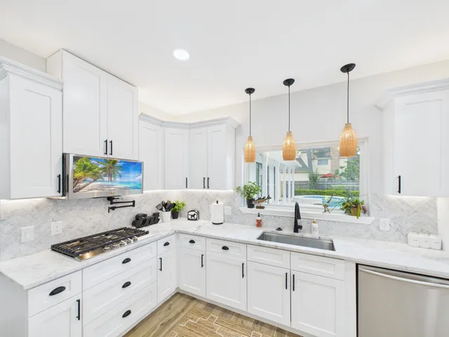 a kitchen with stainless steel appliances granite countertop a sink a stove and a wooden floors