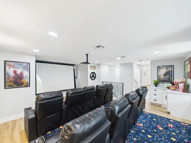 a living room with furniture a large window and wooden floor
