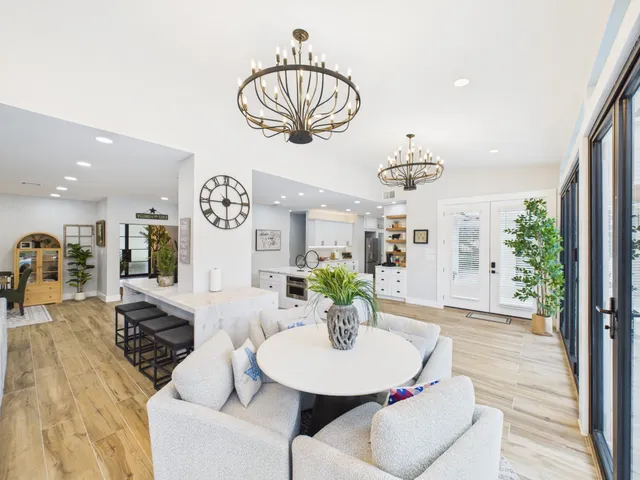 a living room with furniture a chandelier and a dining room