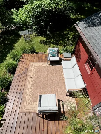 a view of a patio with couches table and chairs with wooden floor and fence