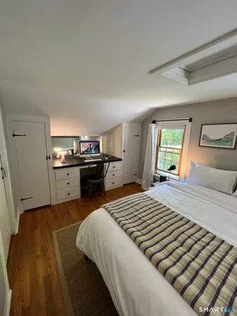 a bedroom with a bed and dresser with mirror