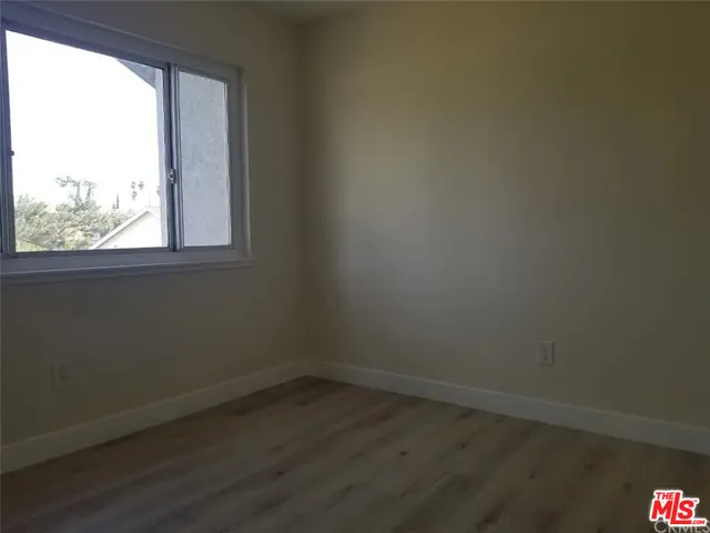 a view of a small space with wooden floor and a window
