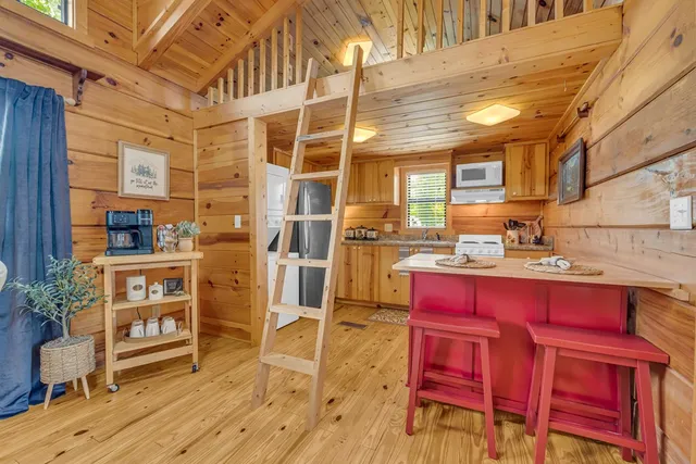 a kitchen with red cabinets and wooden floor
