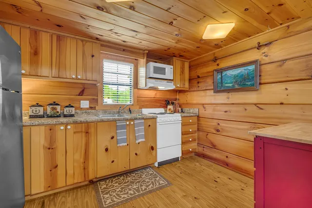 a kitchen with granite countertop cabinets stainless steel appliances and wooden floor