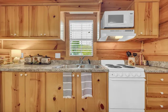 a kitchen with granite countertop cabinets stainless steel appliances and a sink