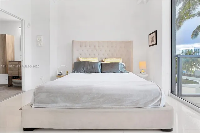 a bedroom with a bed and a refrigerator