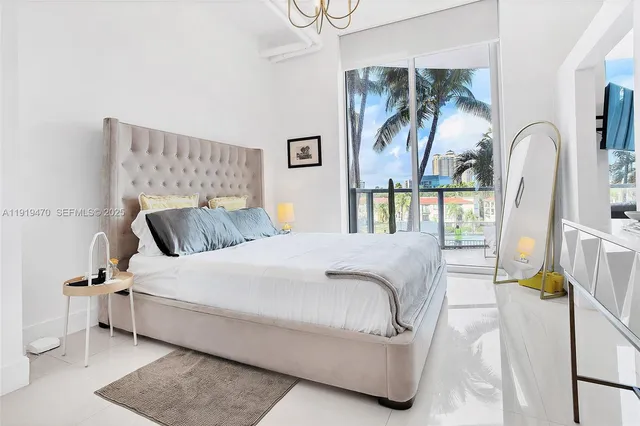 a bedroom with a large bed and a chandelier