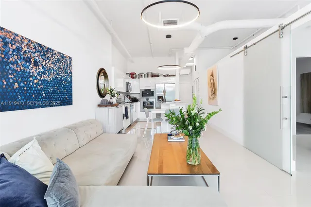 a living room with furniture flowerpot and a chandelier