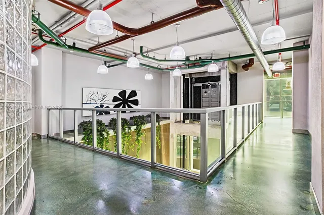 a dining room with stainless steel appliances kitchen island granite countertop a dining table chairs and a chandelier