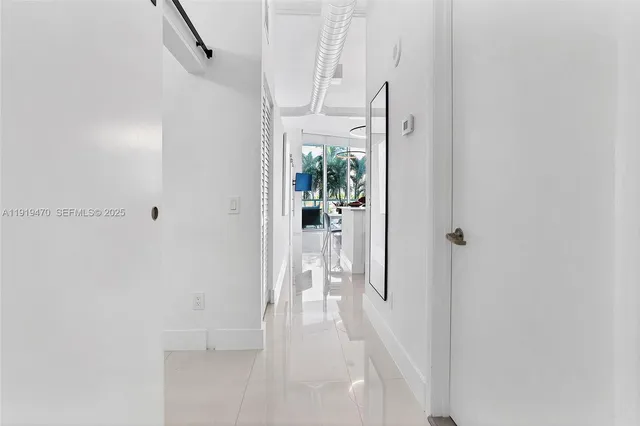 a view of a hallway with wooden floor and entryway