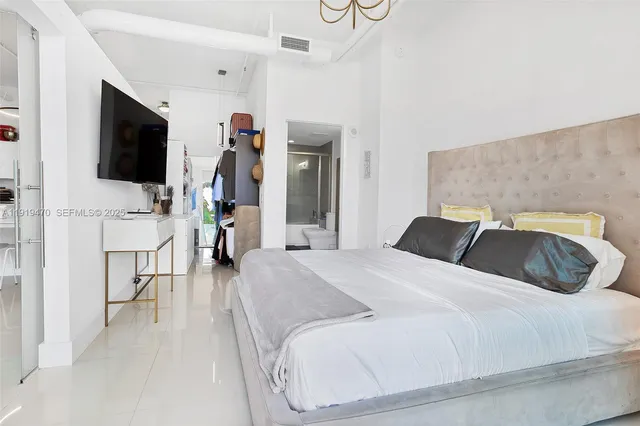 a bed room with a bed and a flat screen tv