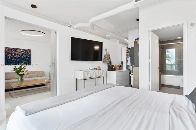 a bedroom with a bed and a flat screen tv