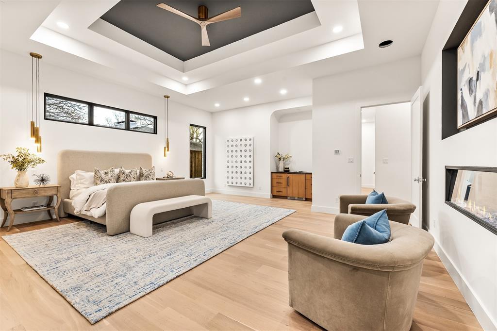 6123 Northaven Road Dallas, TX 75230 - Photo 21 of 40 Tray ceilings and custom lighting add depth and character to the primary bedroom, creating a space that feels intentional and well finished