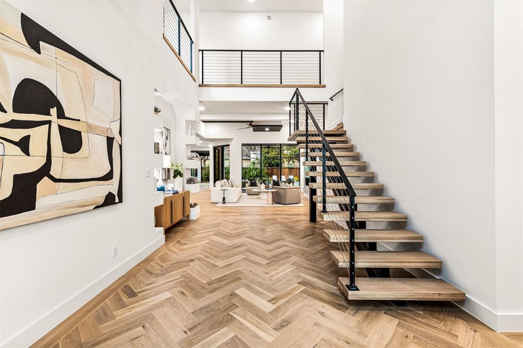 6123 Northaven Road Dallas, TX 75230 - Photo 4 of 40 The modern staircase becomes a focal point right at the entry, adding architectural interest while guiding the natural flow into the main living spaces