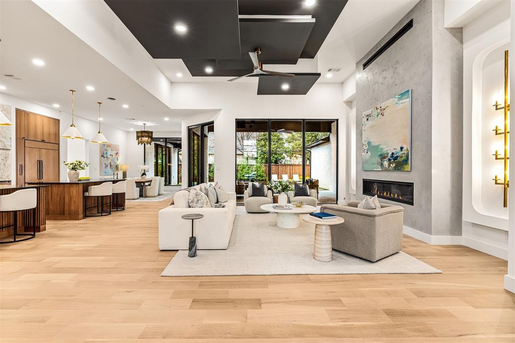 6123 Northaven Road Dallas, TX 75230 - Photo 6 of 40 The living room is anchored by a grand electric fireplace, creating a natural gathering point that adds warmth and presence to the space