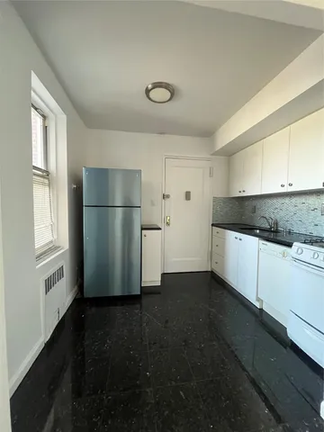a kitchen with a refrigerator and a stove top oven