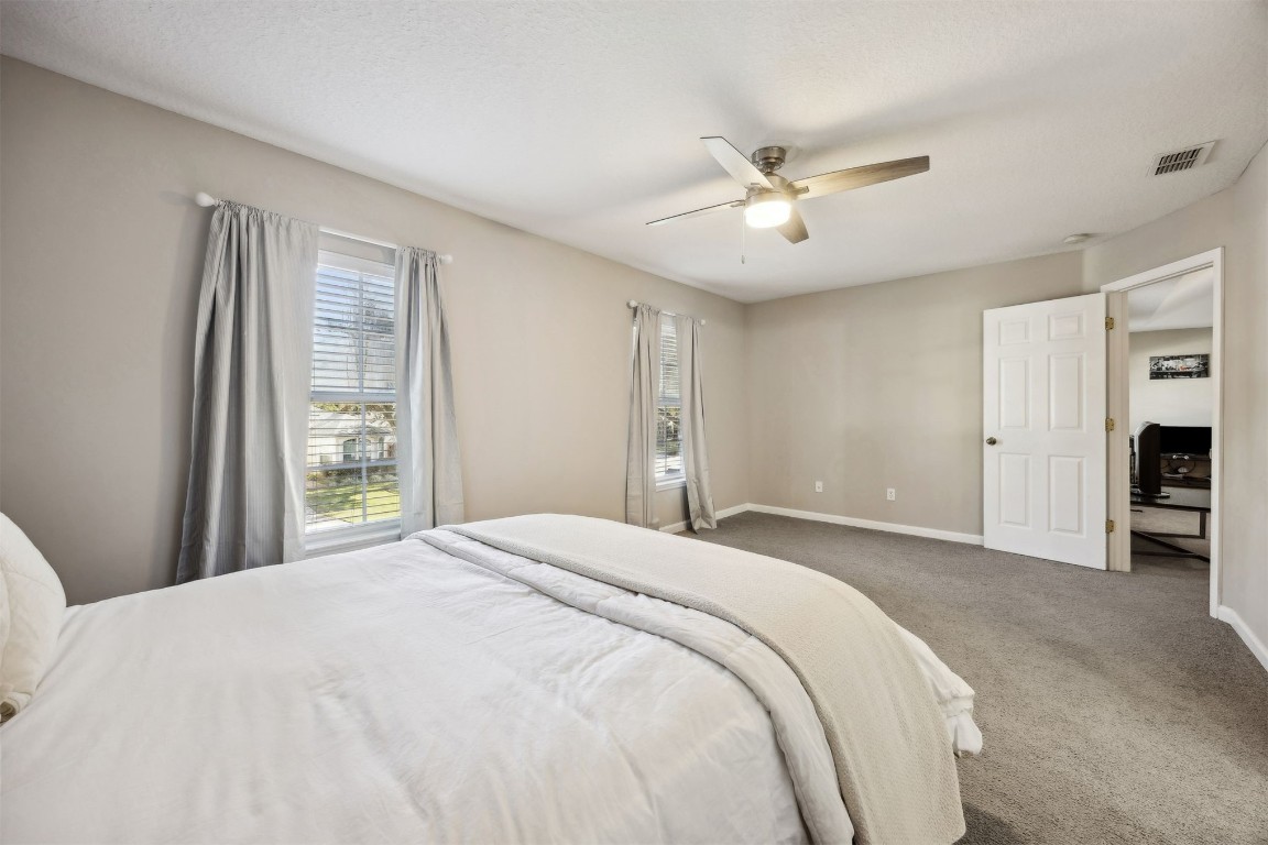 86126 Remsenburg Drive Fernandina Beach, FL 32034 - Photo 20 of 54 a spacious bedroom with a large bed and a chandelier