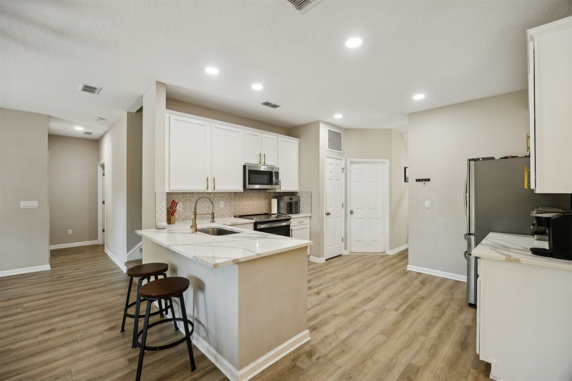 86126 Remsenburg Drive Fernandina Beach, FL 32034 - Photo 8 of 54 a kitchen with a sink a counter top space stainless steel appliances and cabinets