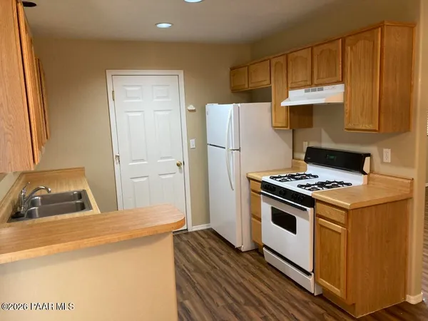 a kitchen with a stove a refrigerator and a sink